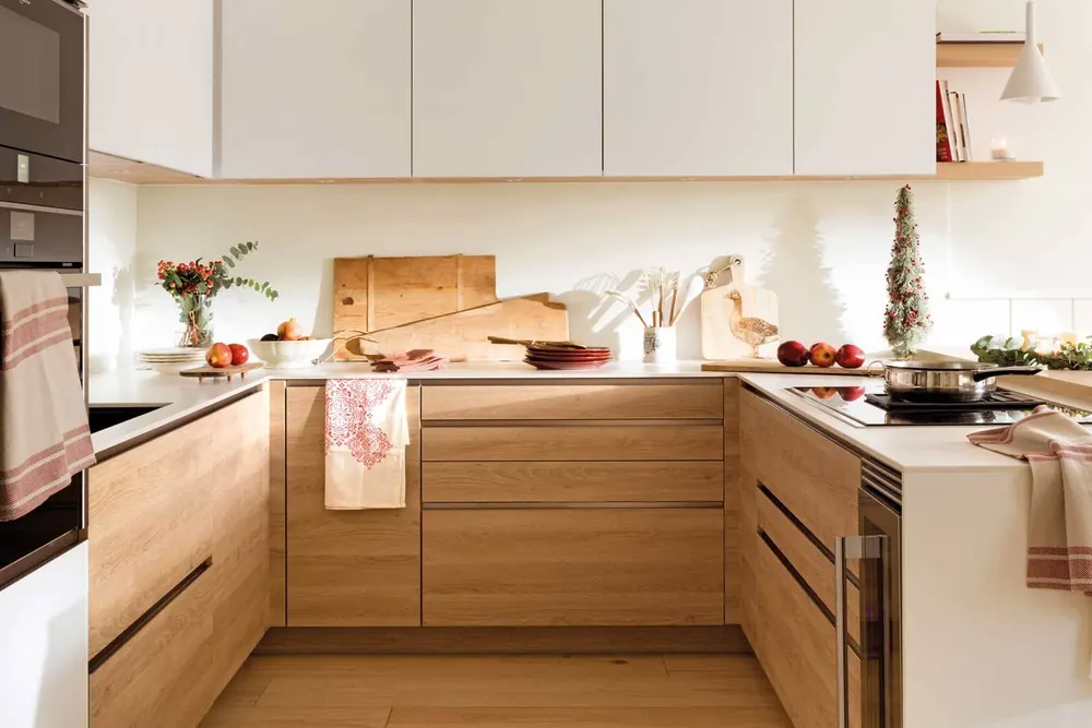 Cocina en U con muebles bajos de madera, armarios altos blancos y placa de inducción