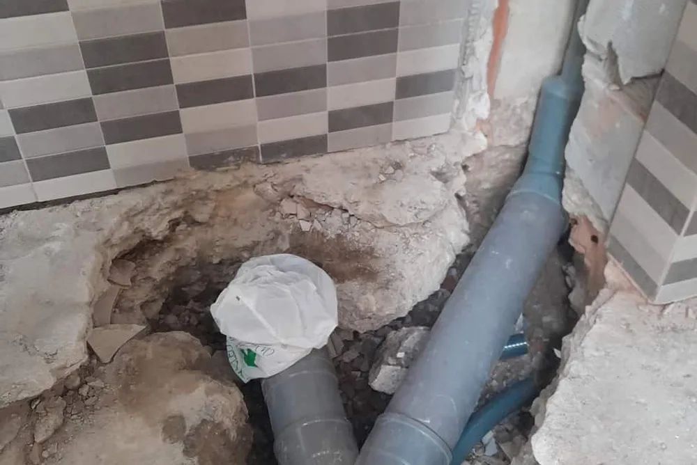 Desagües y bajante a la vista tras levantar el suelo de un baño en una reforma
